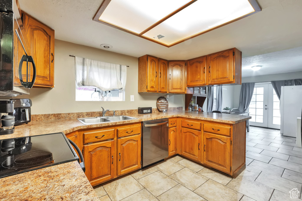 Kitchen with a sink, dishwasher, and brown cabinets