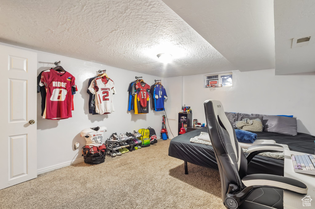 Bedroom featuring carpet, baseboards, and a textured ceiling