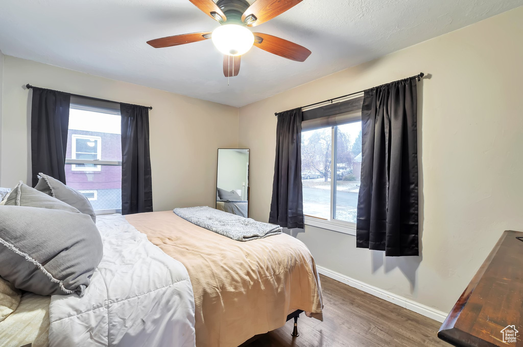Bedroom with baseboards, wood finished floors, and ceiling fan