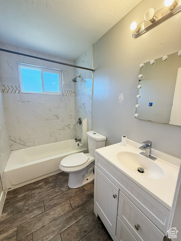 Full bath featuring vanity, tub / shower combination, wood tiled floors, and a textured ceiling