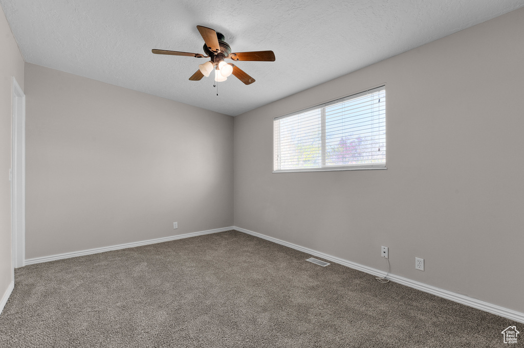 Empty room featuring a ceiling fan, carpet flooring, and baseboards