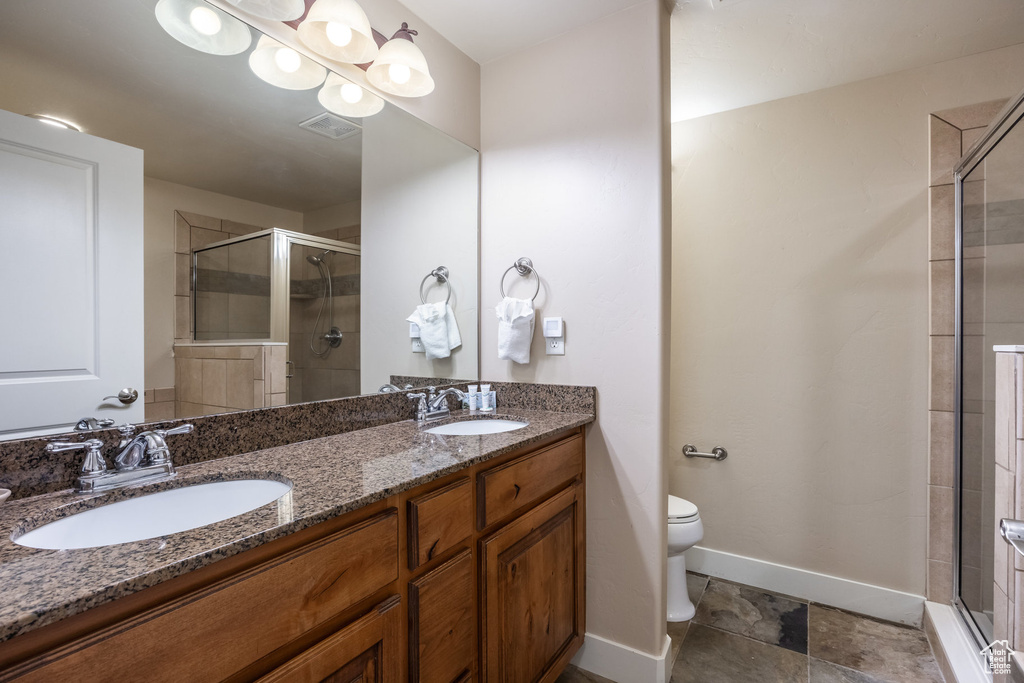 Bathroom with a stall shower, toilet, and a sink