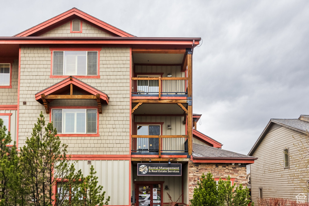 View of front of house featuring board and batten siding and a balcony