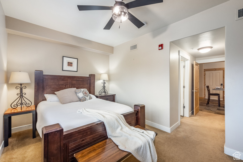 Bedroom with light colored carpet, visible vents, ceiling fan, and baseboards