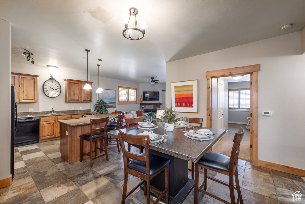 Dining area with a wealth of natural light, ceiling fan, stone finish floor, and baseboards