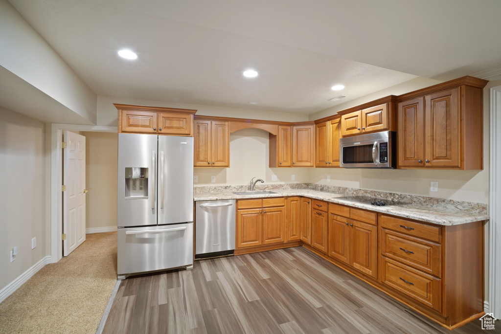Kitchen with recessed lighting, light stone countertops, a sink, and stainless steel appliances