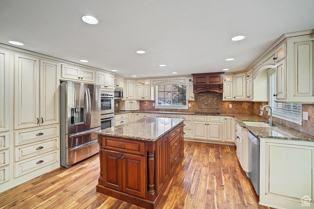 Kitchen with stainless steel appliances, cream cabinets, and a sink