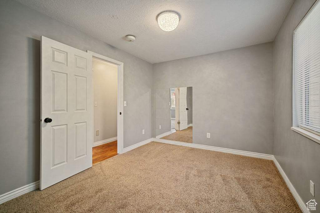 Unfurnished bedroom with carpet floors and baseboards