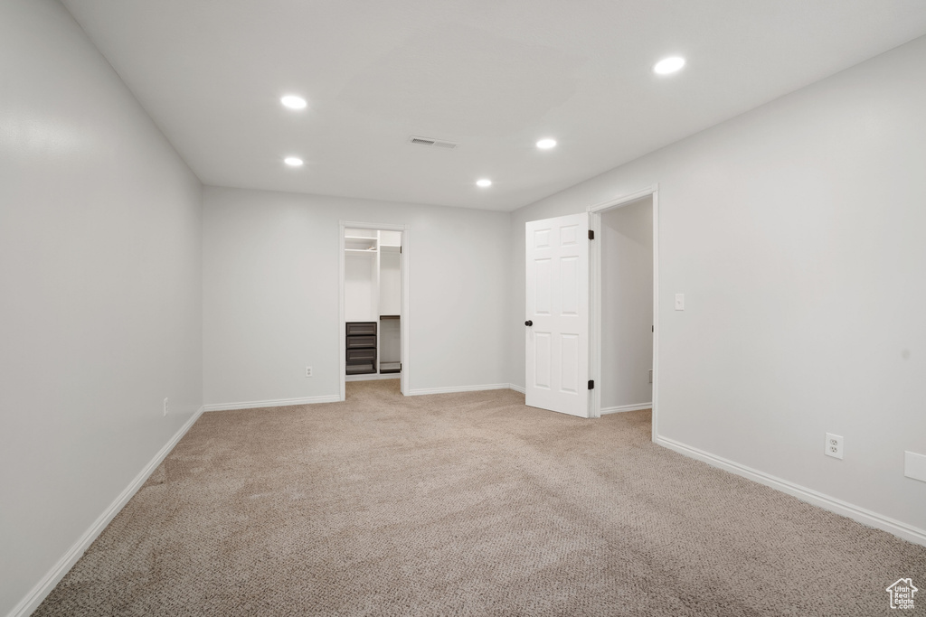 Unfurnished bedroom with light colored carpet, visible vents, recessed lighting, and baseboards