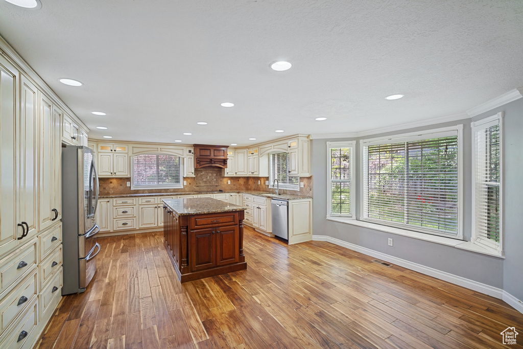 Kitchen featuring appliances with stainless steel finishes, a sink, hardwood / wood-style floors, and baseboards