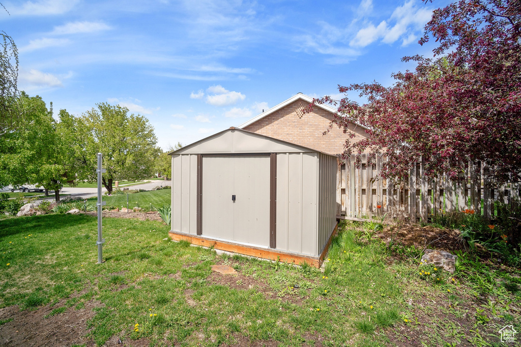 View of shed featuring fence