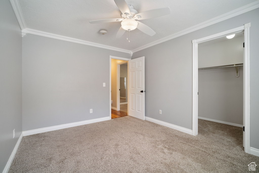 Unfurnished bedroom featuring crown molding and carpet floors