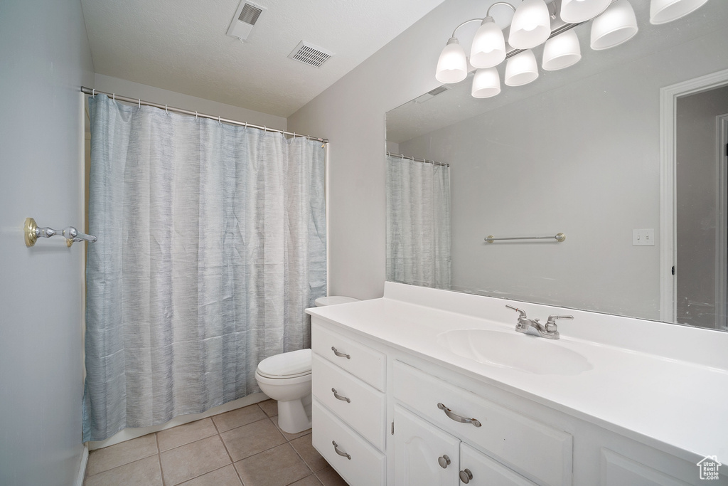 Full bath with vanity, visible vents, toilet, and tile patterned flooring
