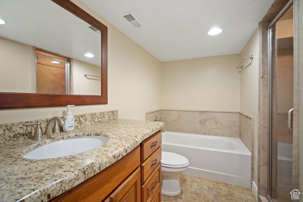 Full bathroom featuring vanity, toilet, a stall shower, visible vents, and a garden tub