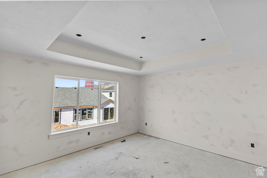 Unfurnished room with a raised ceiling and baseboards