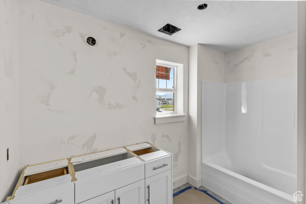 Full bathroom featuring shower / tub combination and baseboards