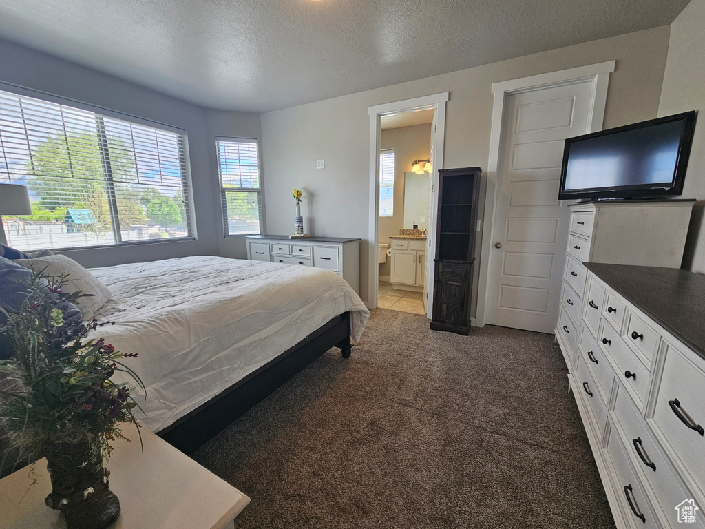 Carpeted bedroom with a textured ceiling and ensuite bathroom
