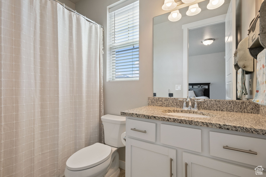 Bathroom with toilet, ensuite bathroom, and vanity