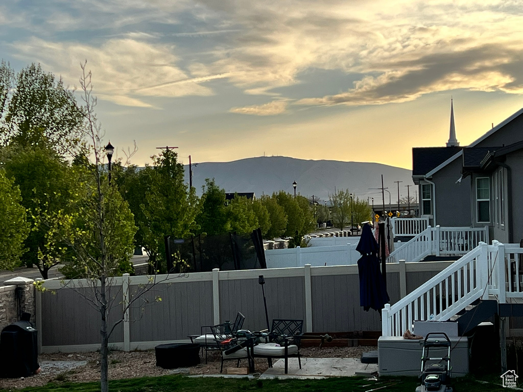 View of yard featuring a fenced backyard, a deck with mountain view, and stairway