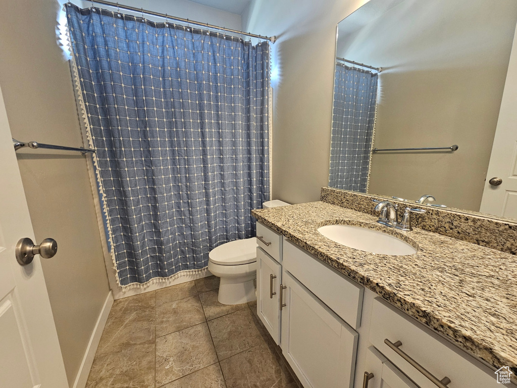 Bathroom featuring vanity, tile patterned flooring, a shower with curtain, and toilet