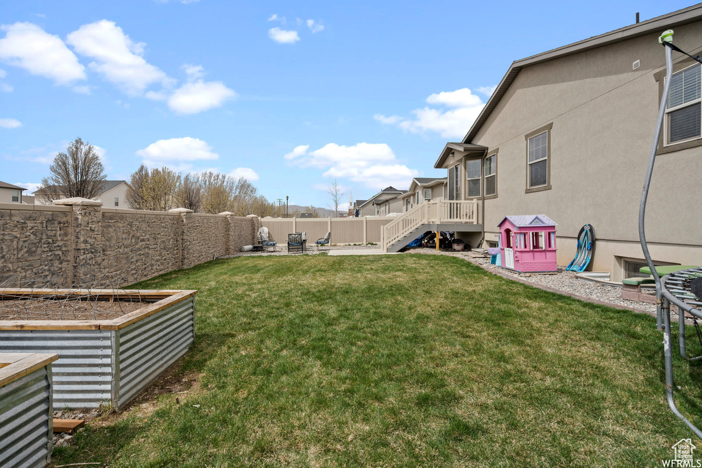 View of yard with a patio, a fenced backyard, stairs, and a vegetable garden