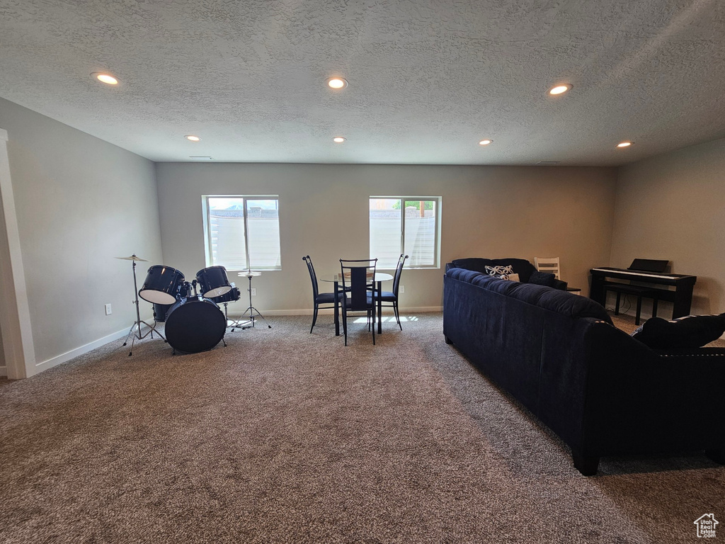 Carpeted living area with recessed lighting, a textured ceiling, and baseboards