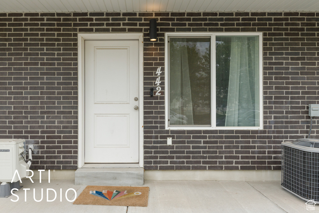 Entrance to property with central AC and brick siding
