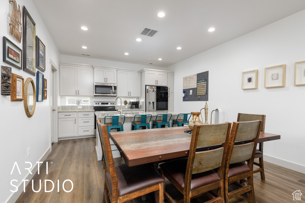 Dining space with recessed lighting, visible vents, wood finished floors, and baseboards