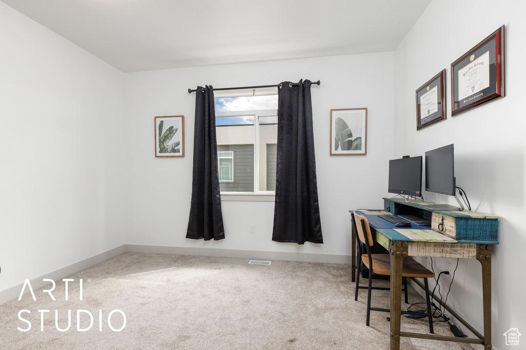 Office area with visible vents, baseboards, and carpet floors