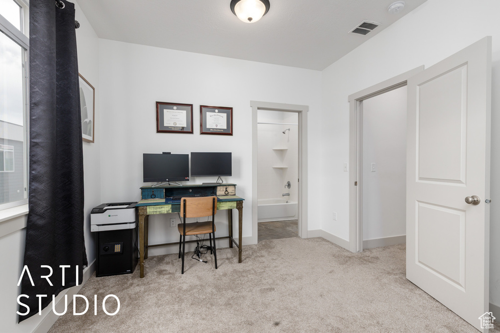 Carpeted office space with visible vents and baseboards