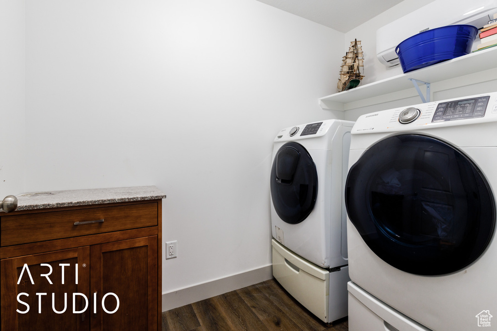 Washroom with baseboards, dark wood-style floors, laundry area, and washing machine and dryer