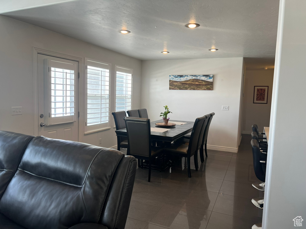 Tiled dining room featuring baseboards