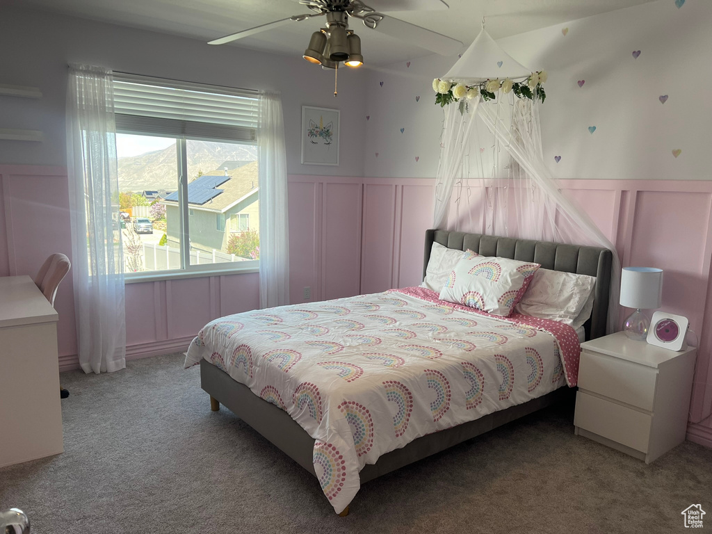 Bedroom featuring a wainscoted wall, carpet floors, and a decorative wall