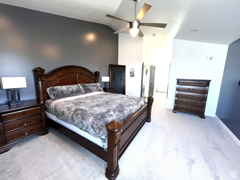 Bedroom with baseboards, light carpet, ceiling fan, and vaulted ceiling