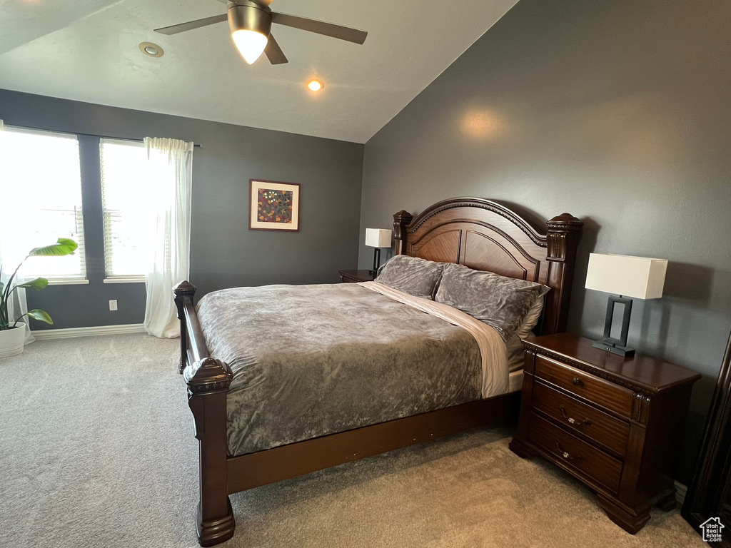 Bedroom with light colored carpet, ceiling fan, baseboards, recessed lighting, and vaulted ceiling