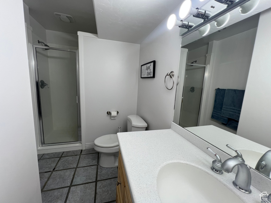 Bathroom featuring toilet, a stall shower, visible vents, and vanity