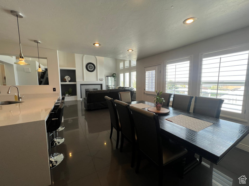 Dining area with recessed lighting, built in shelves, a tile fireplace, and dark tile patterned flooring