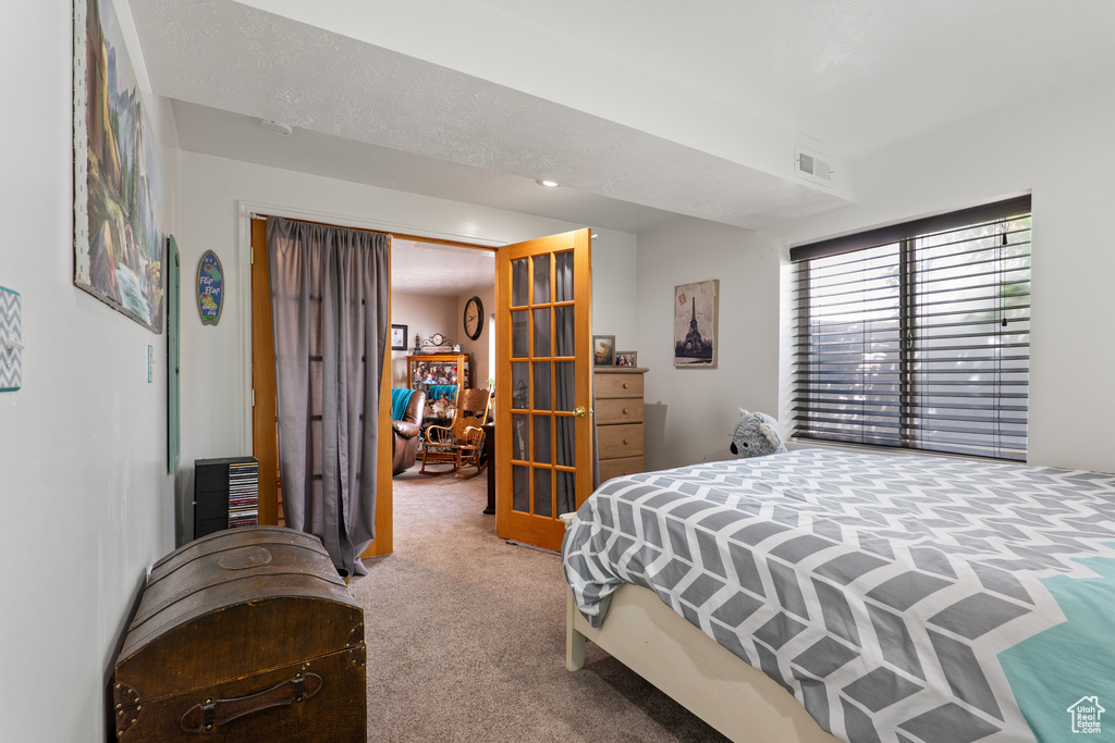 Carpeted bedroom featuring visible vents and french doors