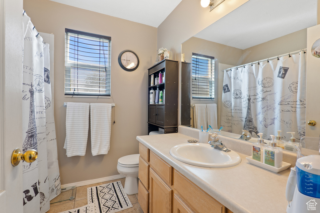 Bathroom with tile patterned flooring, a shower with curtain, toilet, vanity, and baseboards