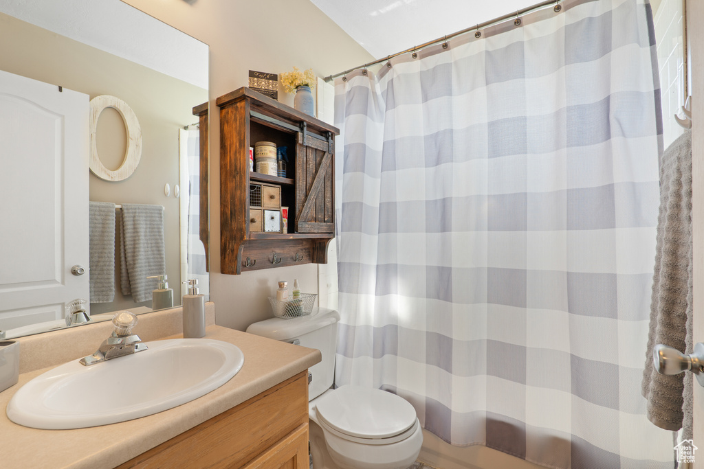 Full bathroom with toilet, a shower with curtain, and vanity