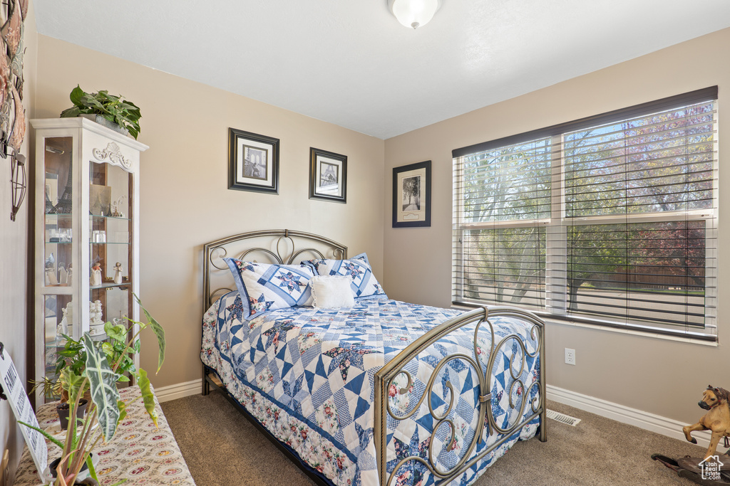 Carpeted bedroom with visible vents and baseboards
