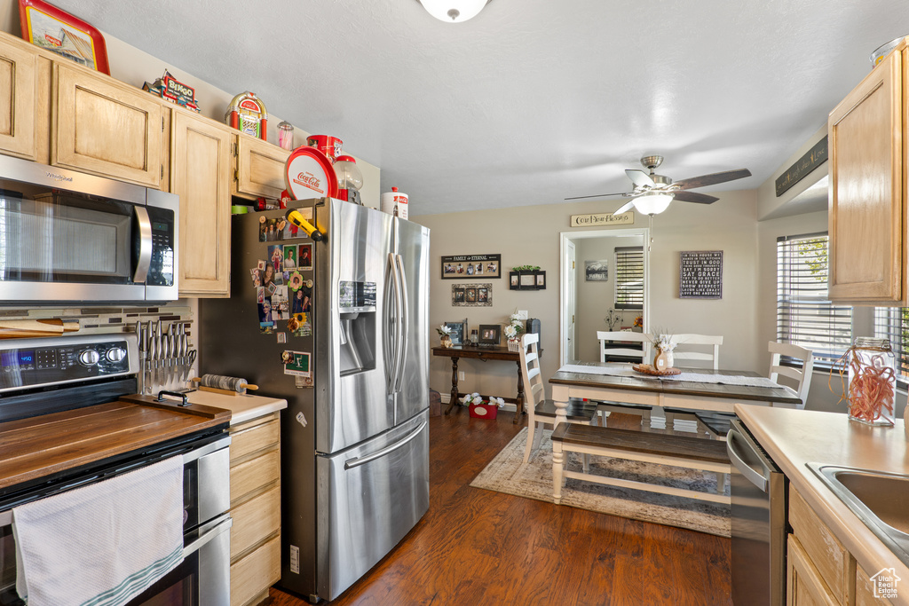 Kitchen featuring stainless steel appliances, light brown cabinetry, a ceiling fan, light countertops, and dark wood finished floors