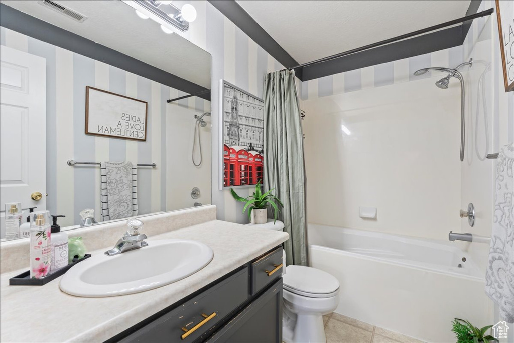 Full bathroom featuring vanity, shower / bath combination with curtain, toilet, visible vents, and tile patterned flooring