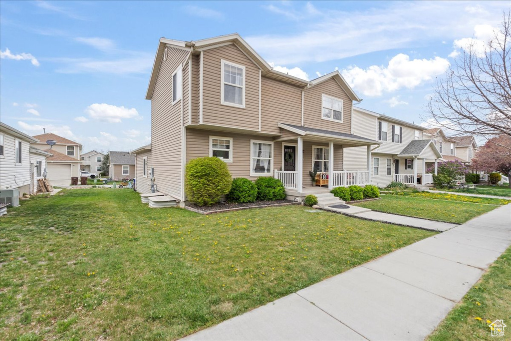 Townhome / multi-family property featuring a porch, a front yard, and a residential view