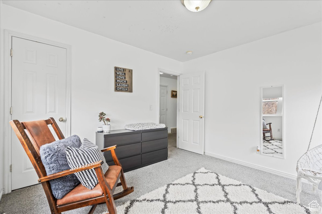 Living area featuring baseboards and light colored carpet