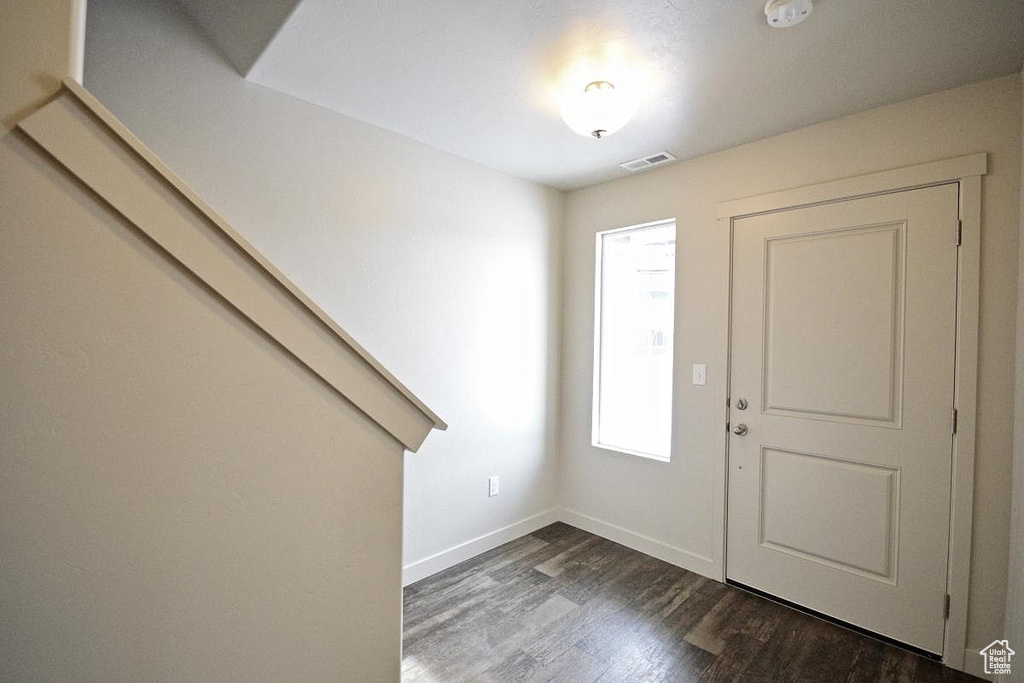 Foyer featuring visible vents, dark wood-style floors, and baseboards
