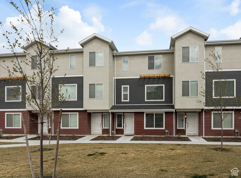 View of property with stucco siding and a front yard