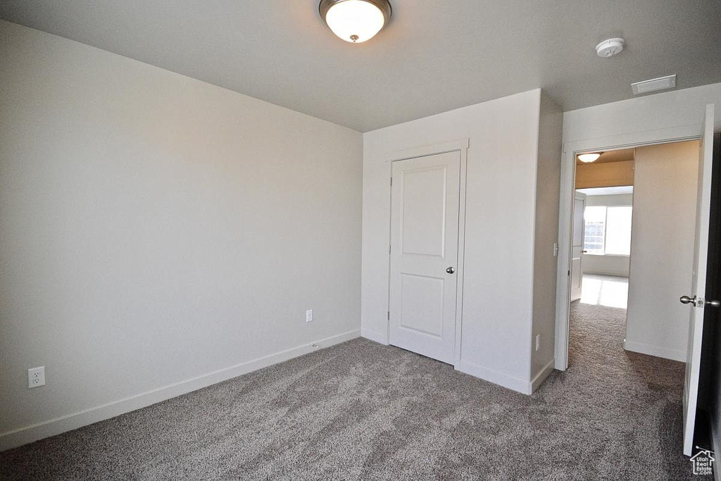 Unfurnished bedroom featuring carpet and baseboards