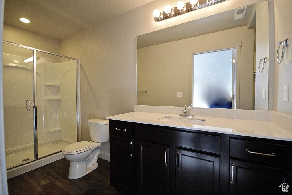 Full bath featuring visible vents, a stall shower, toilet, wood finished floors, and vanity