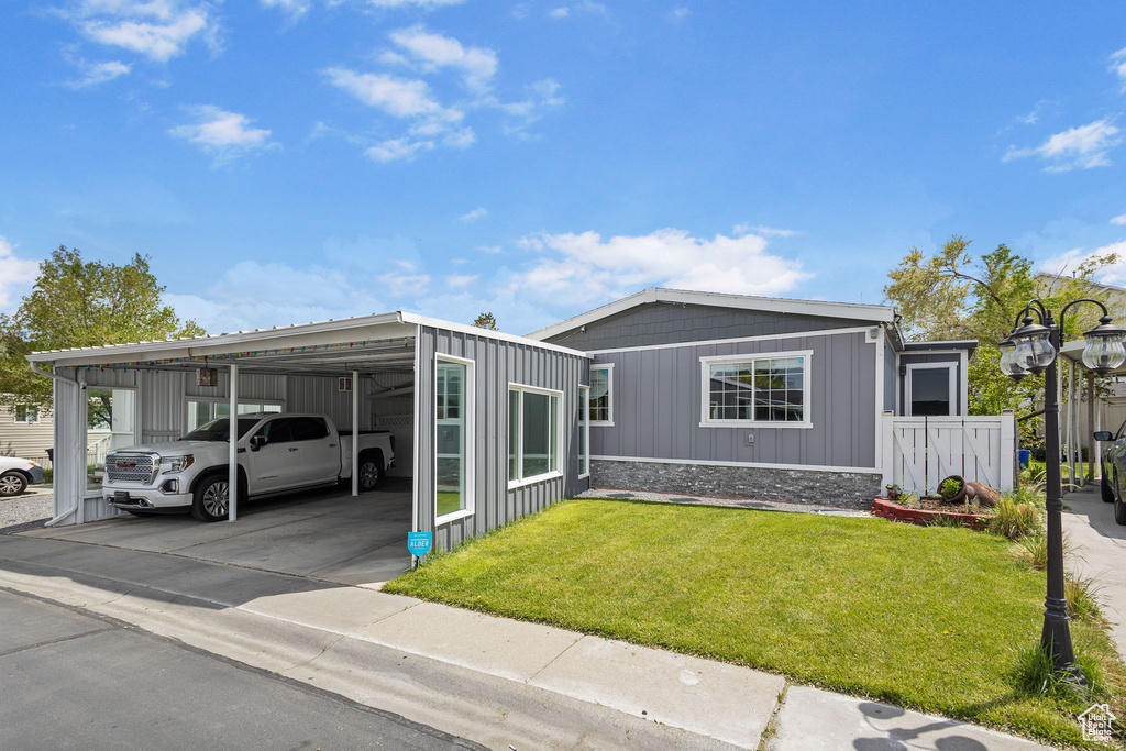 Manufactured / mobile home featuring a front lawn and board and batten siding